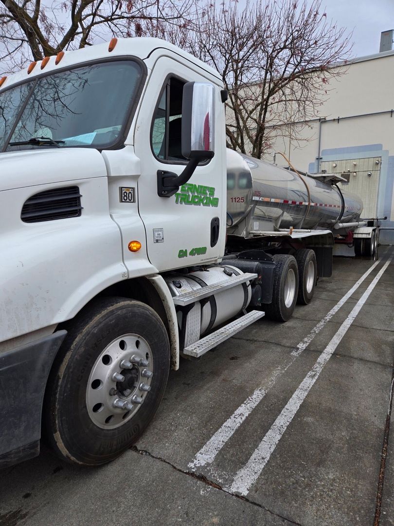 A white semi truck is parked in a parking lot.