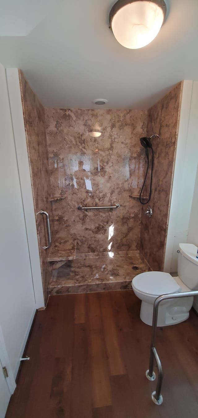 A bathroom with a toilet and a walk in shower.