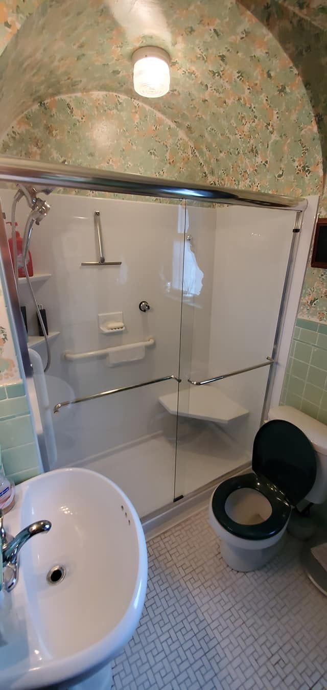 A bathroom with a sink , toilet and shower.