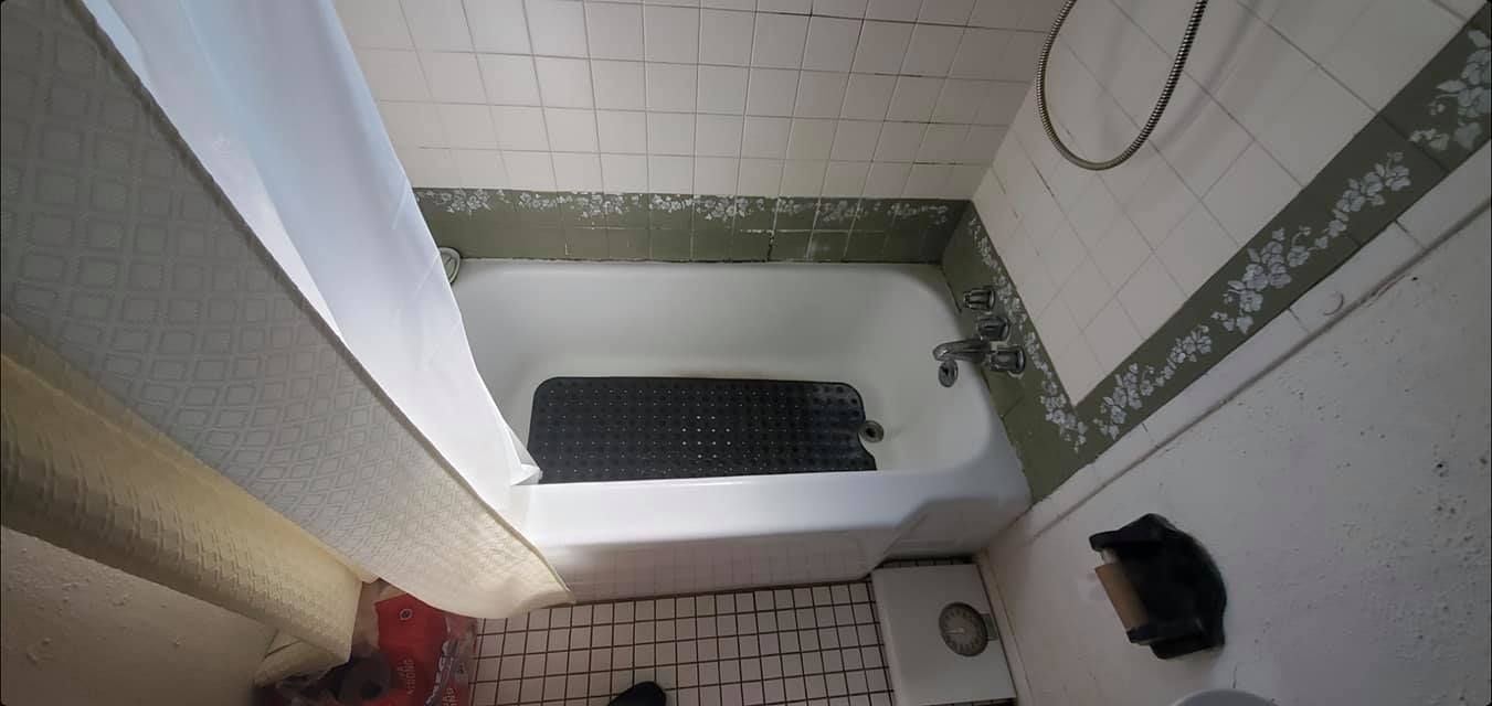 A bathroom with a bathtub and a shower.