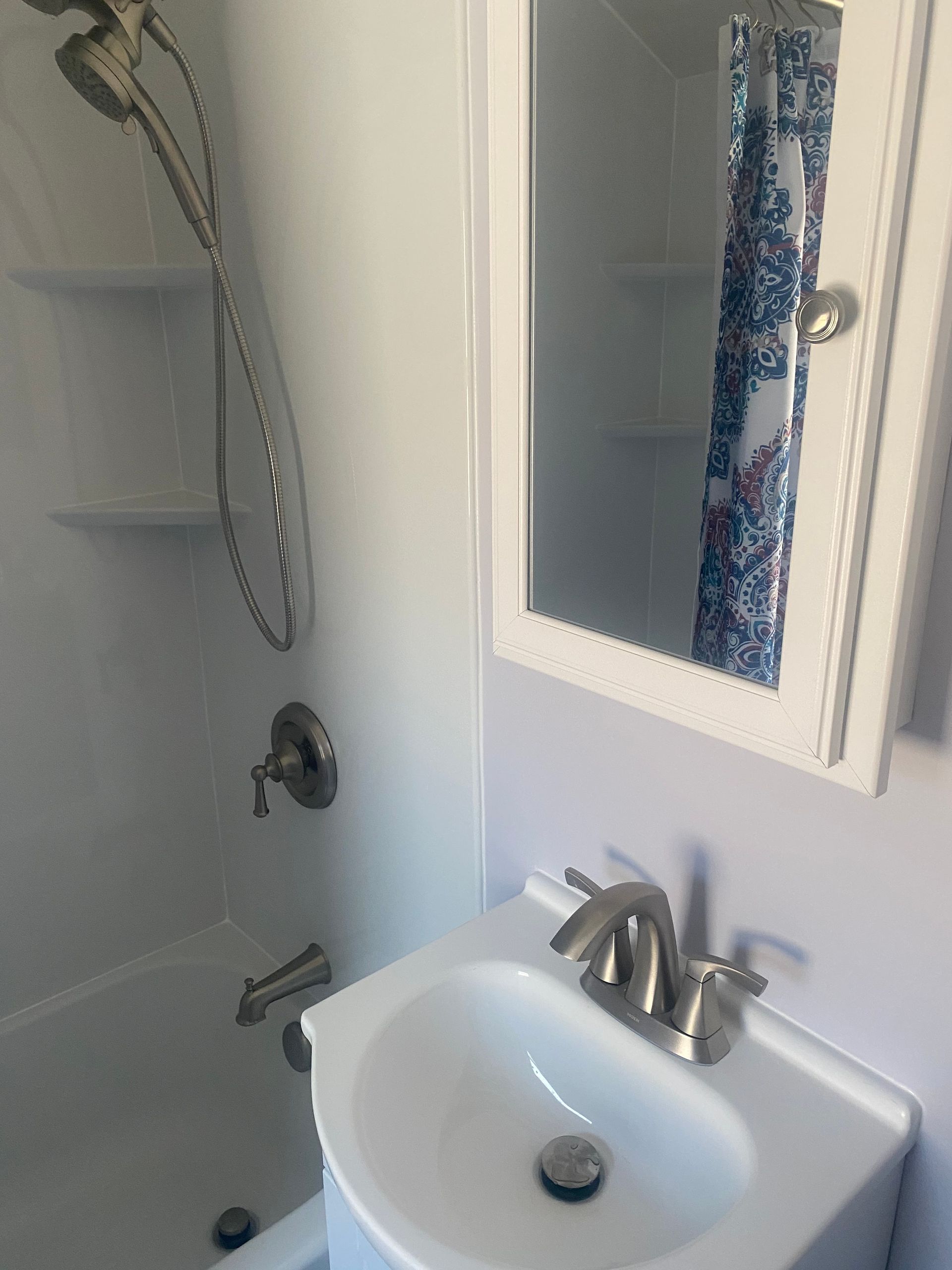 A bathroom with a sink a mirror and a shower