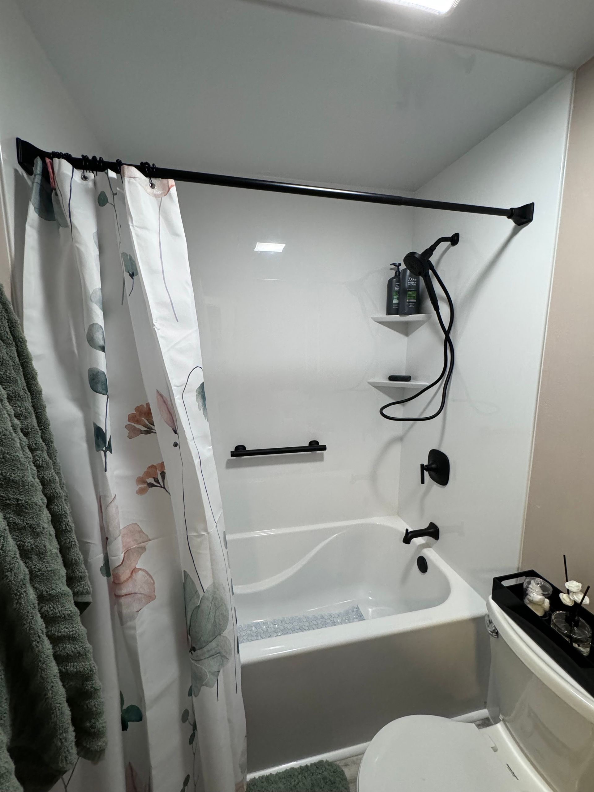 A bathroom with a bathtub , toilet and shower curtain