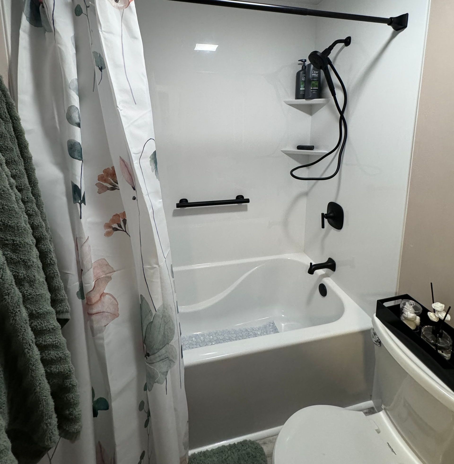 A bathroom with a bathtub , toilet and shower curtain