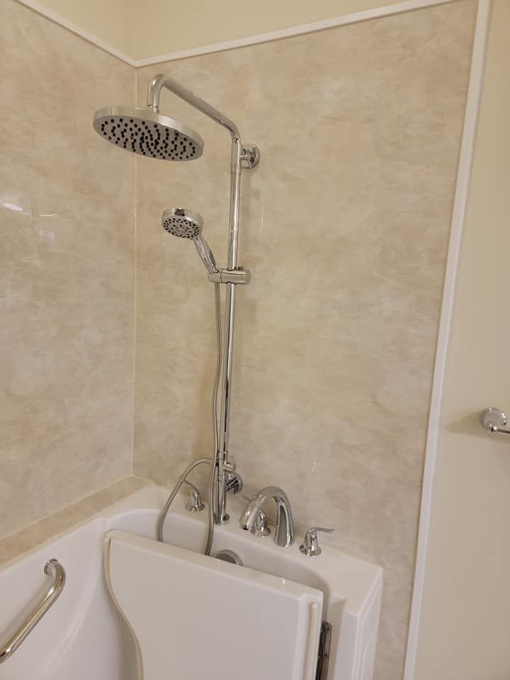 A bathroom with a walk in tub and a shower head.