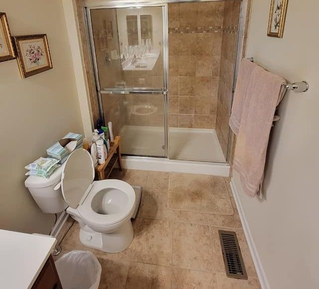 A bathroom with a walk in tub , toilet and shower.