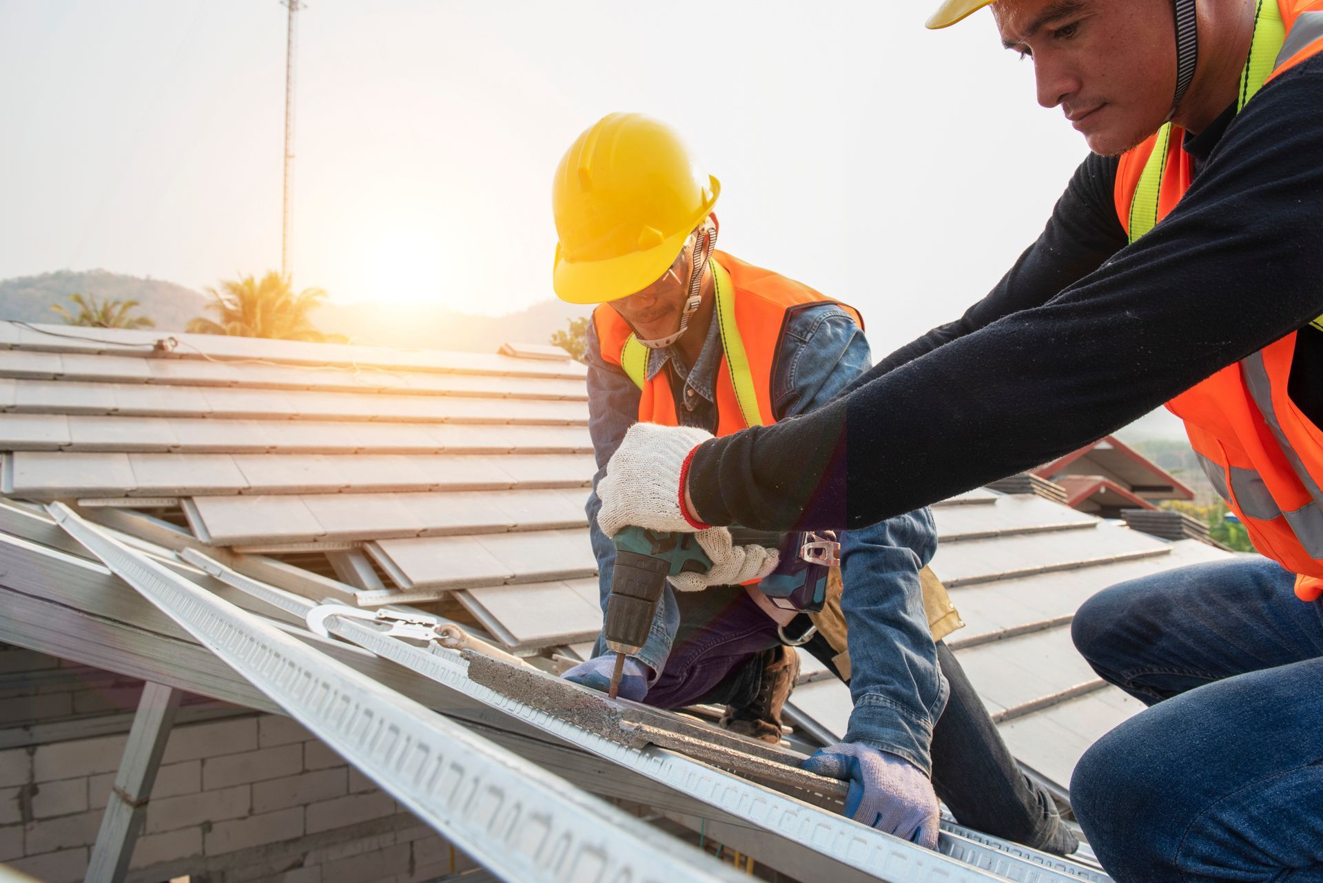 Two construction workers are working on the roof