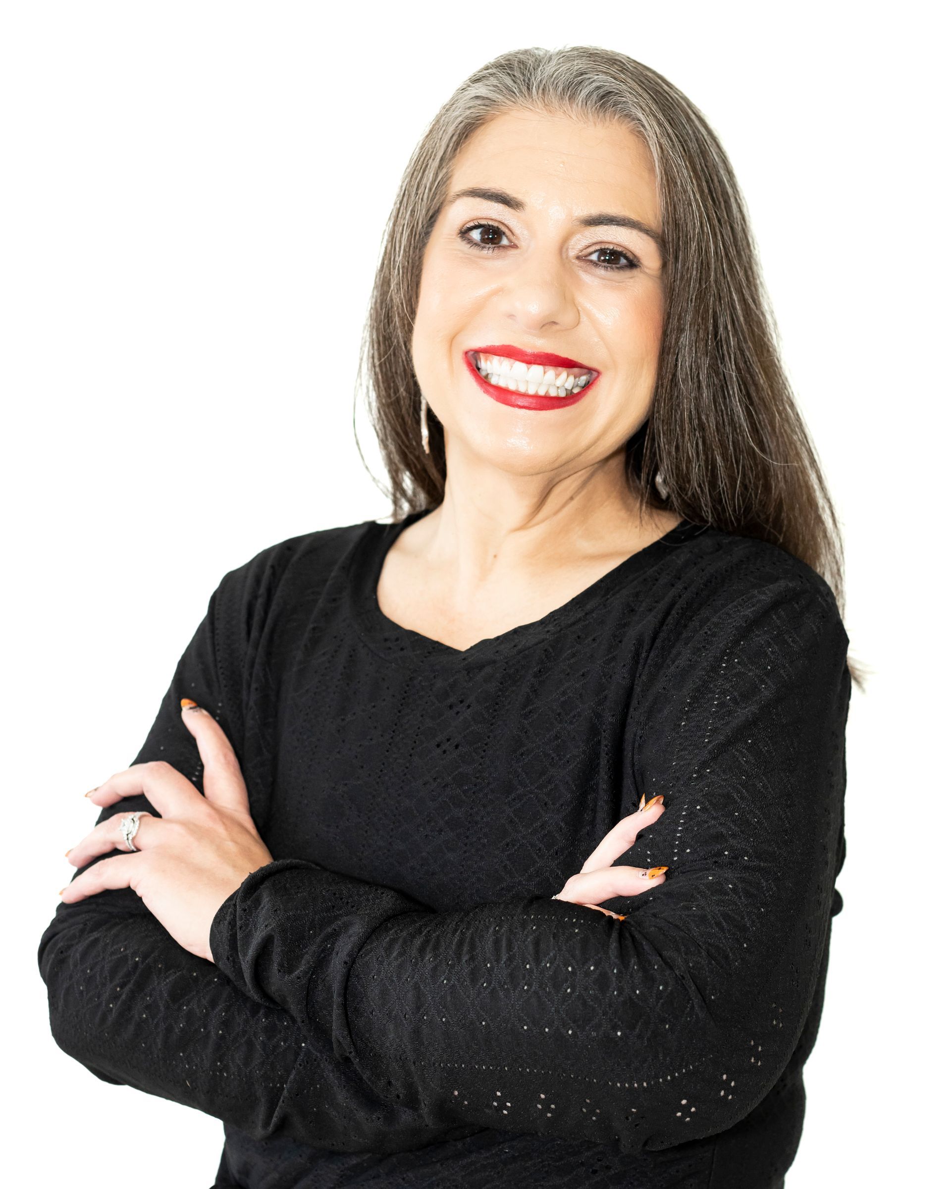 A woman in a black sweater is smiling with her arms crossed