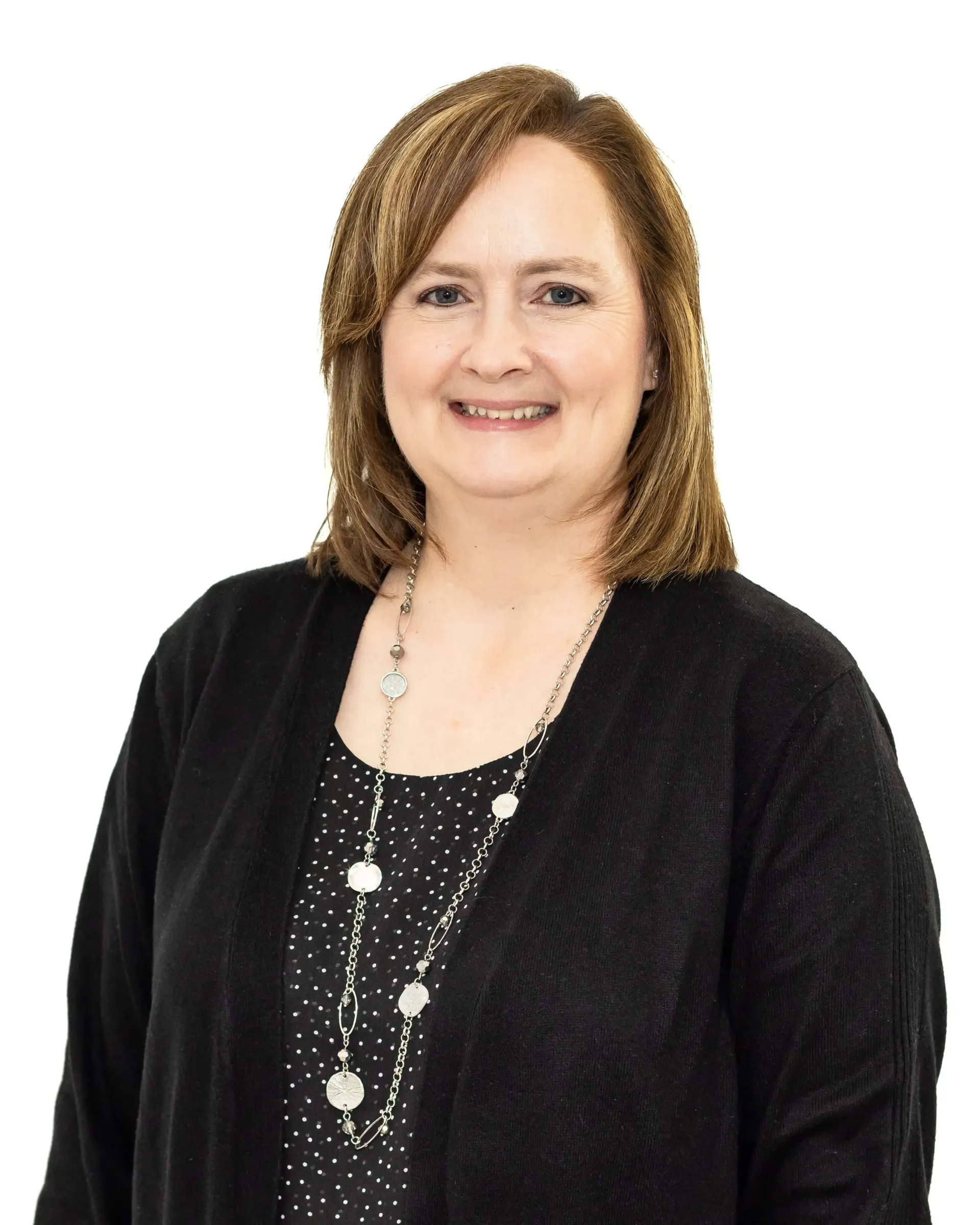 A woman wearing a black sweater and a necklace is smiling for the camera.