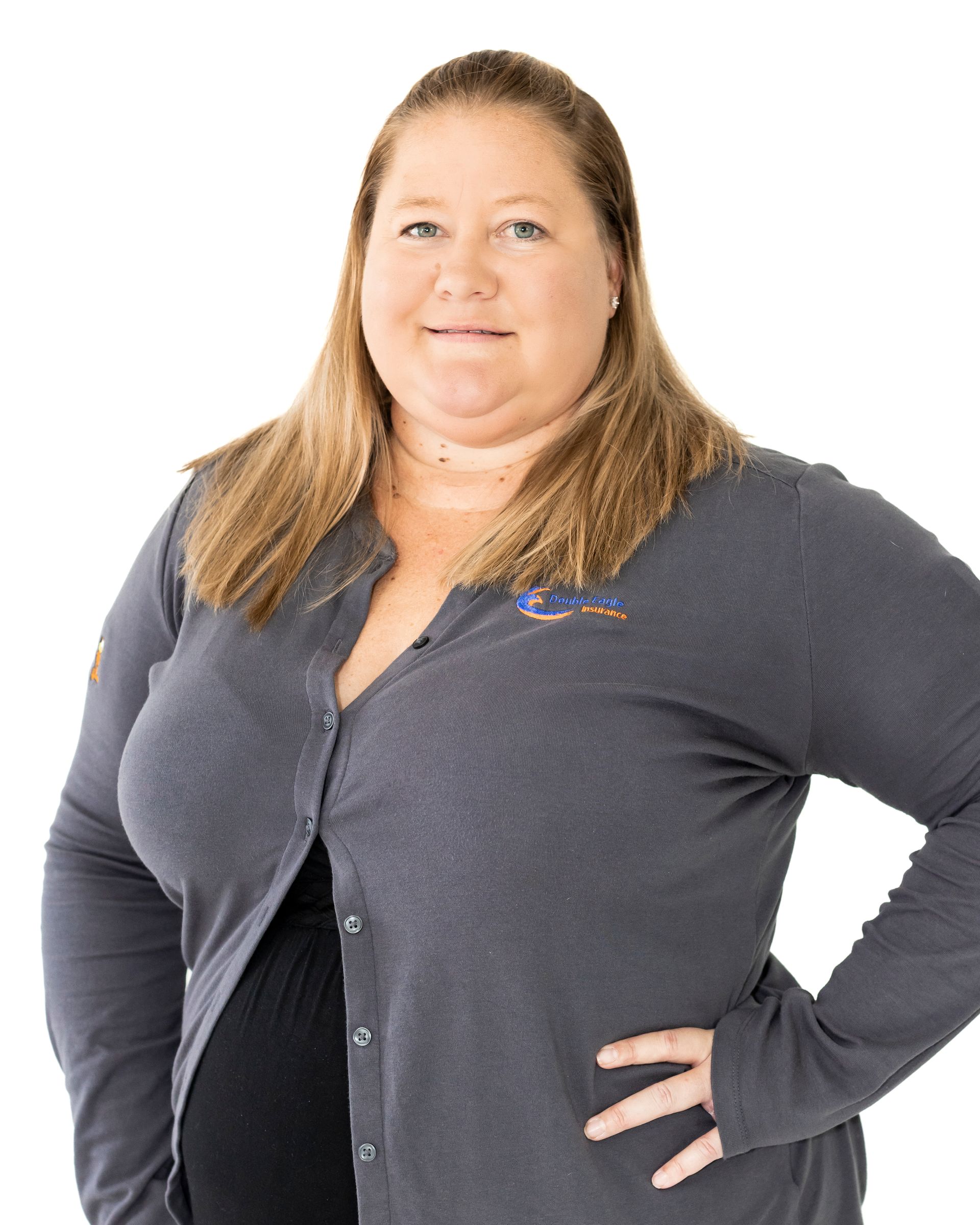 A woman in a gray cardigan is standing with her hands on her hips.