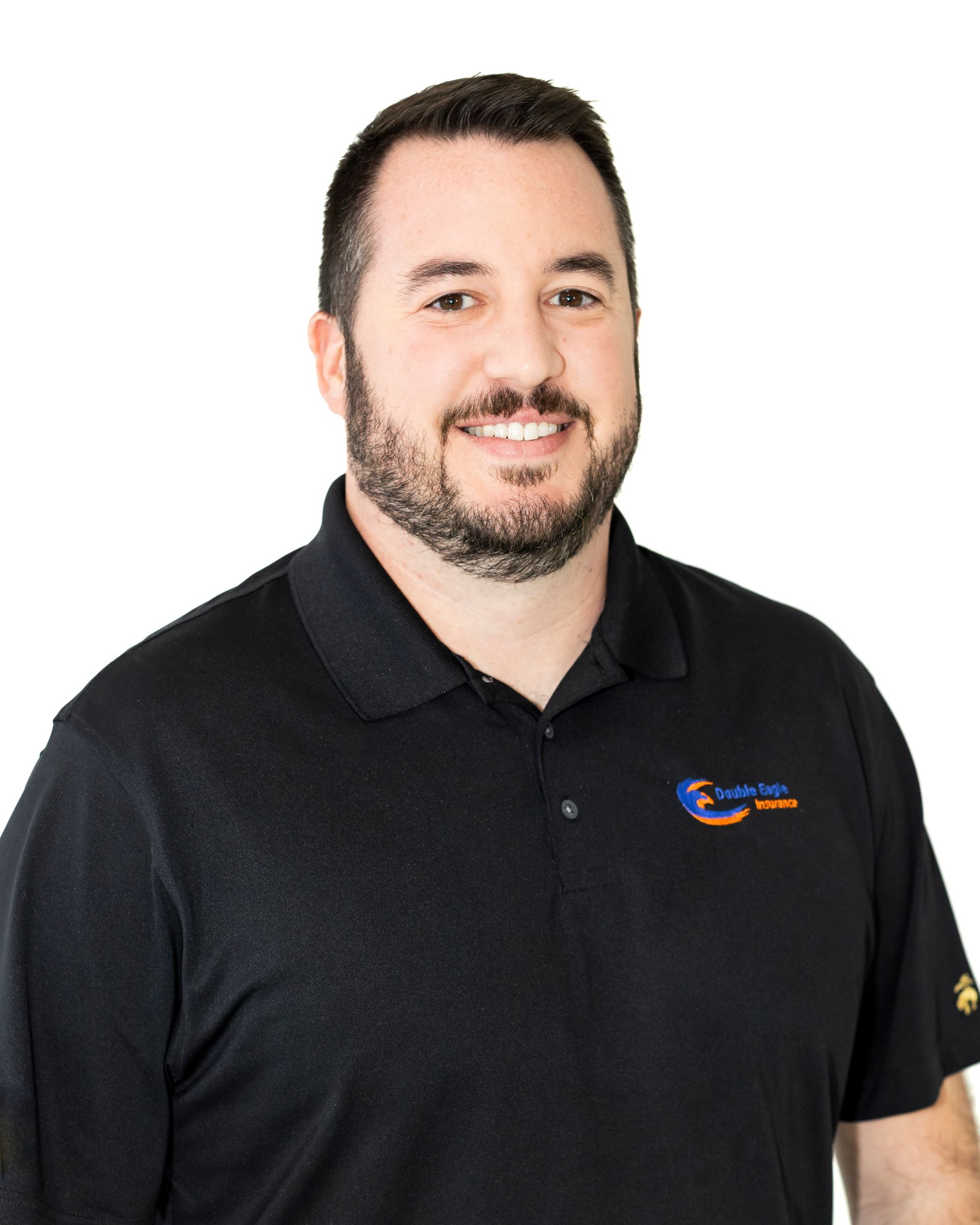 A man with a beard is wearing a black shirt and smiling.