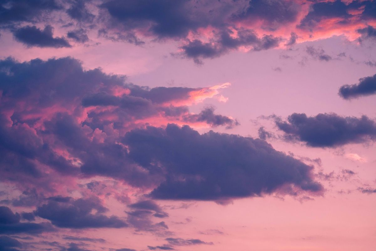 Pink and purple sunset sky with dark, fluffy clouds.