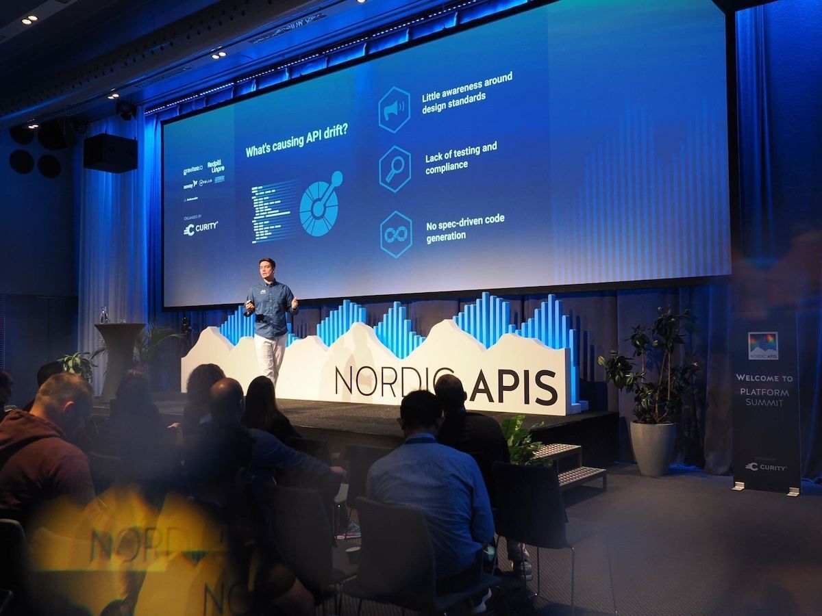 Man presenting at the Nordic APIs conference, standing in front of a screen, with audience.