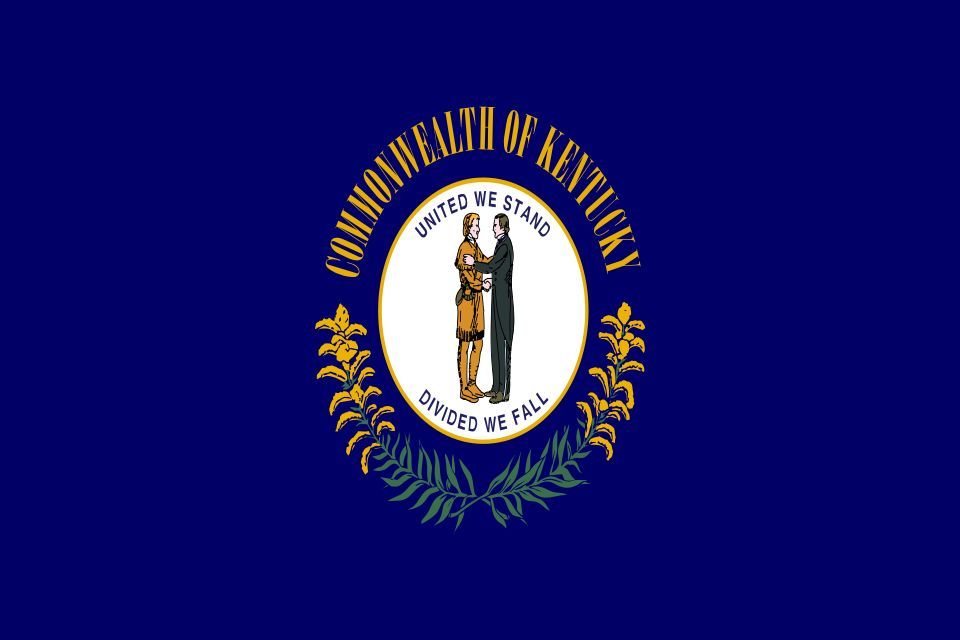 Flag of Kentucky: navy field with the Commonwealth seal — two figures clasping hands above the motto 'United We Stand, Divided We Fall' — encircled by goldenrod.