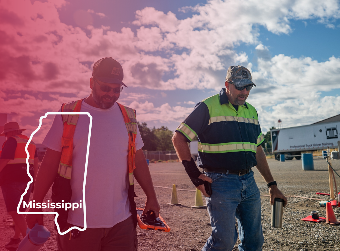 Two CDL instructors in safety vests walk through a CDL training yard with a map overlay of Mississippi.