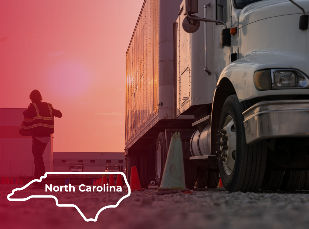 A person in a high-visibility safety vest walks across a gravel lot beside a white semi-truck at sunset in North Carolina, with orange and green traffic cones marking a CDL driver training course.