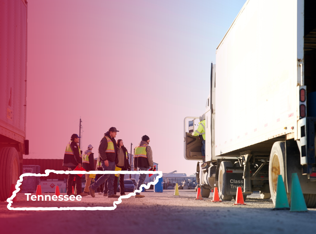 CDL students in safety vests stand near large trucks in a yard, overlaid with a white outline of the state of Tennessee.