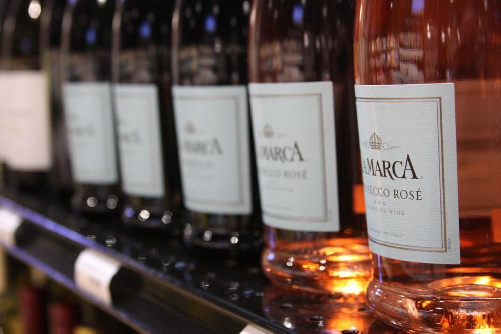 A row of La Marca Prosecco Rosé wine bottles displayed on a store shelf.