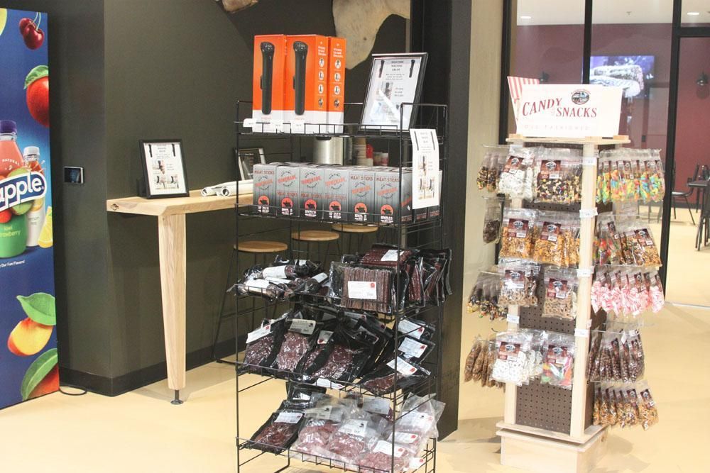 A retail display with a metal rack of packaged snacks and a rotating stand labeled 