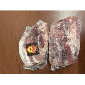 Two large, raw, vacuum-sealed pork shoulder cuts resting on a wooden surface.