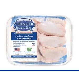A plastic-wrapped tray of raw Springer Mountain Farms chicken wings with a blue and white product label.