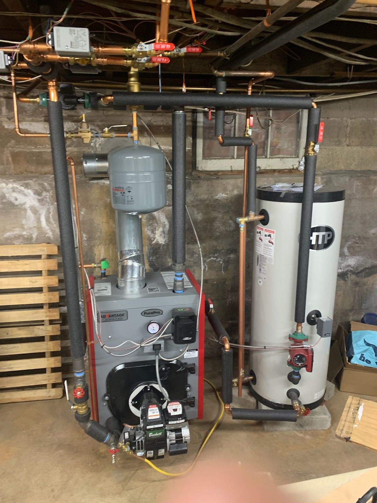 Basement utility room with furnace, water heater, pipes, and exposed ceiling beams