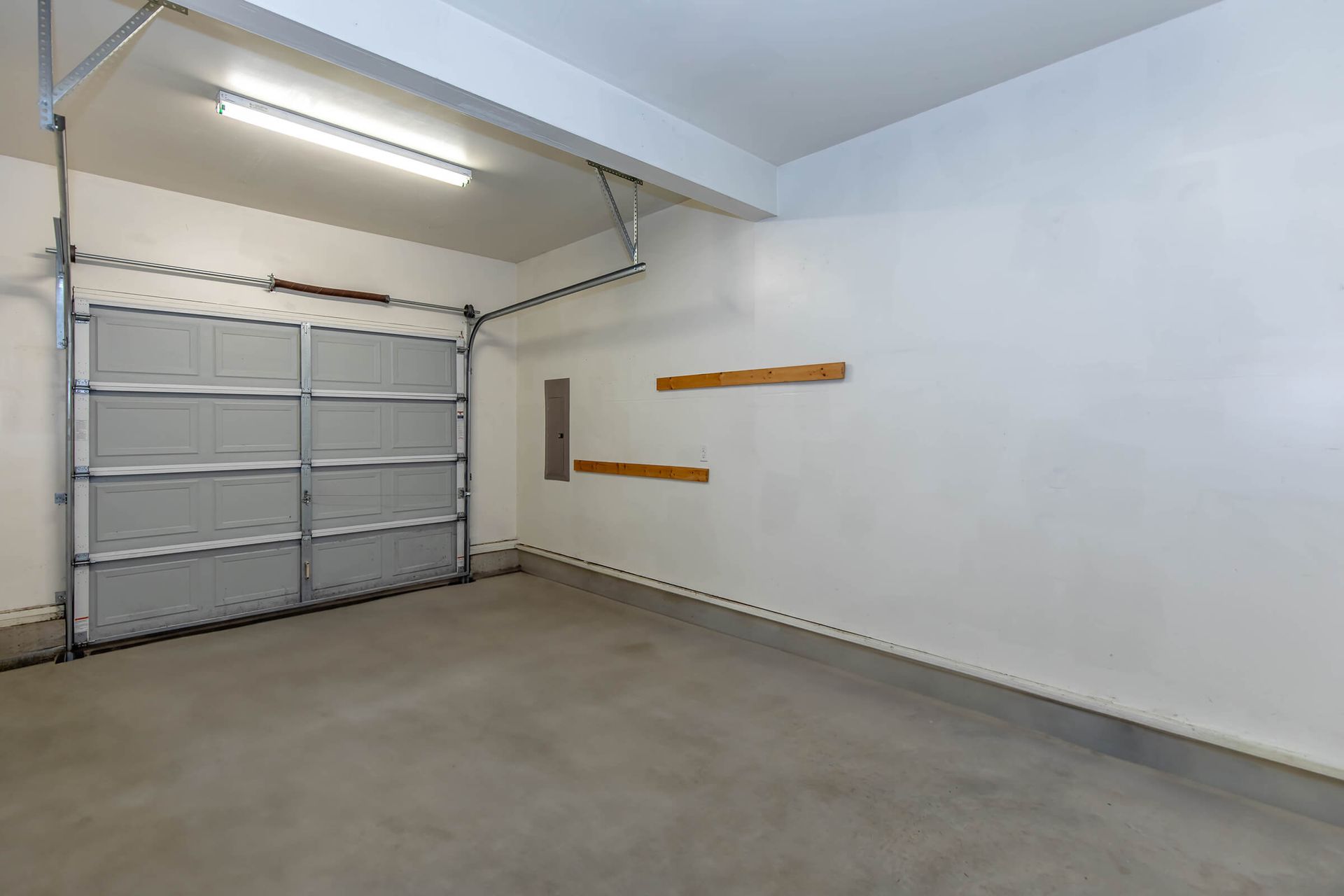 An empty garage with a garage door open.