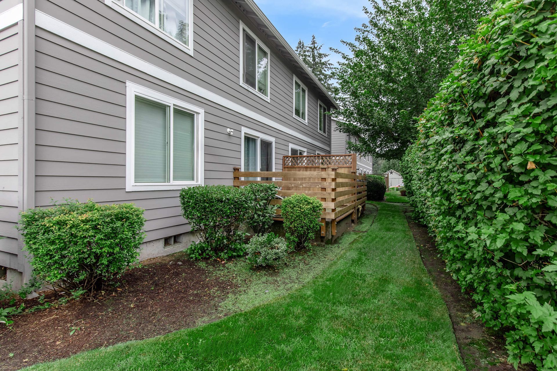 A large apartment building with a lush green lawn in front of it.
