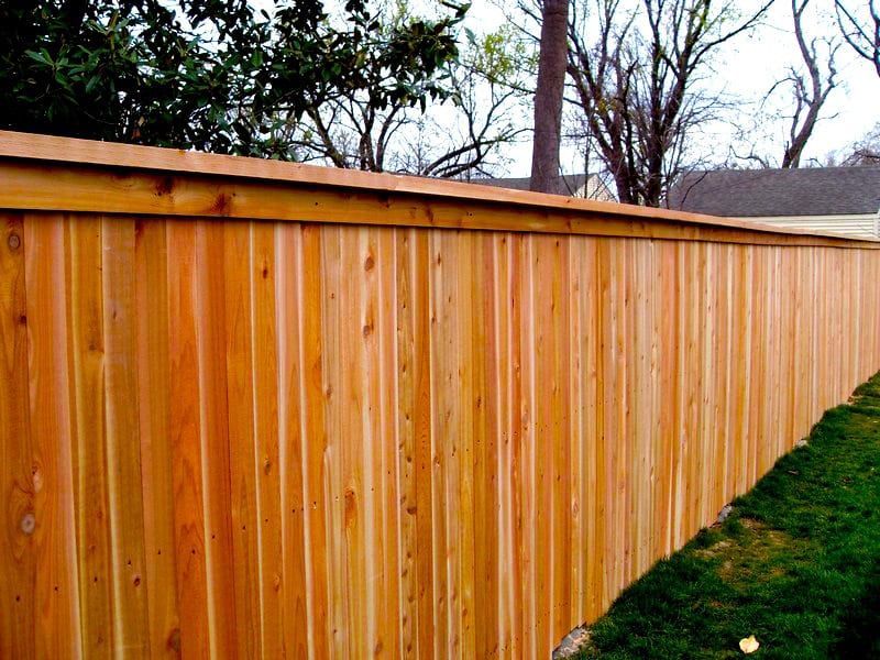 Brown fence with mounted black spotlights.