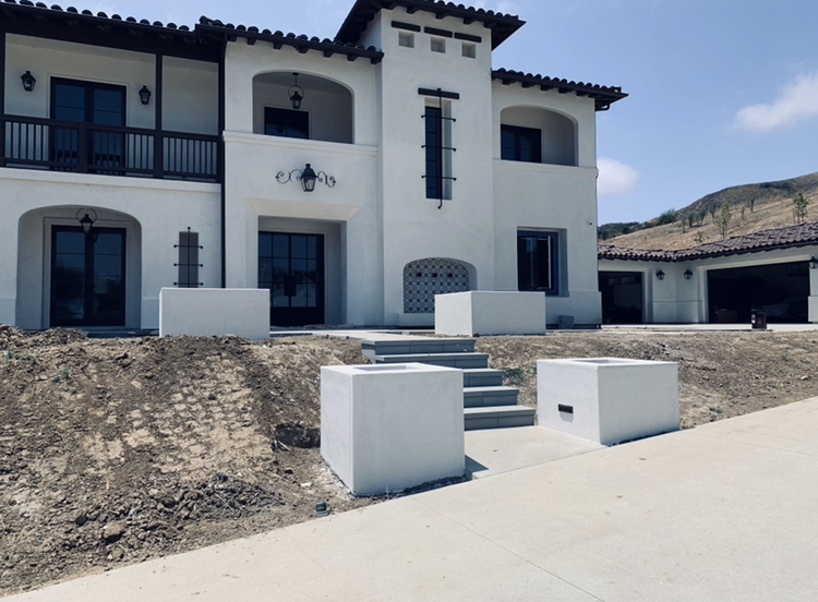 White stucco home with a balcony, two-story entry, and a garage.