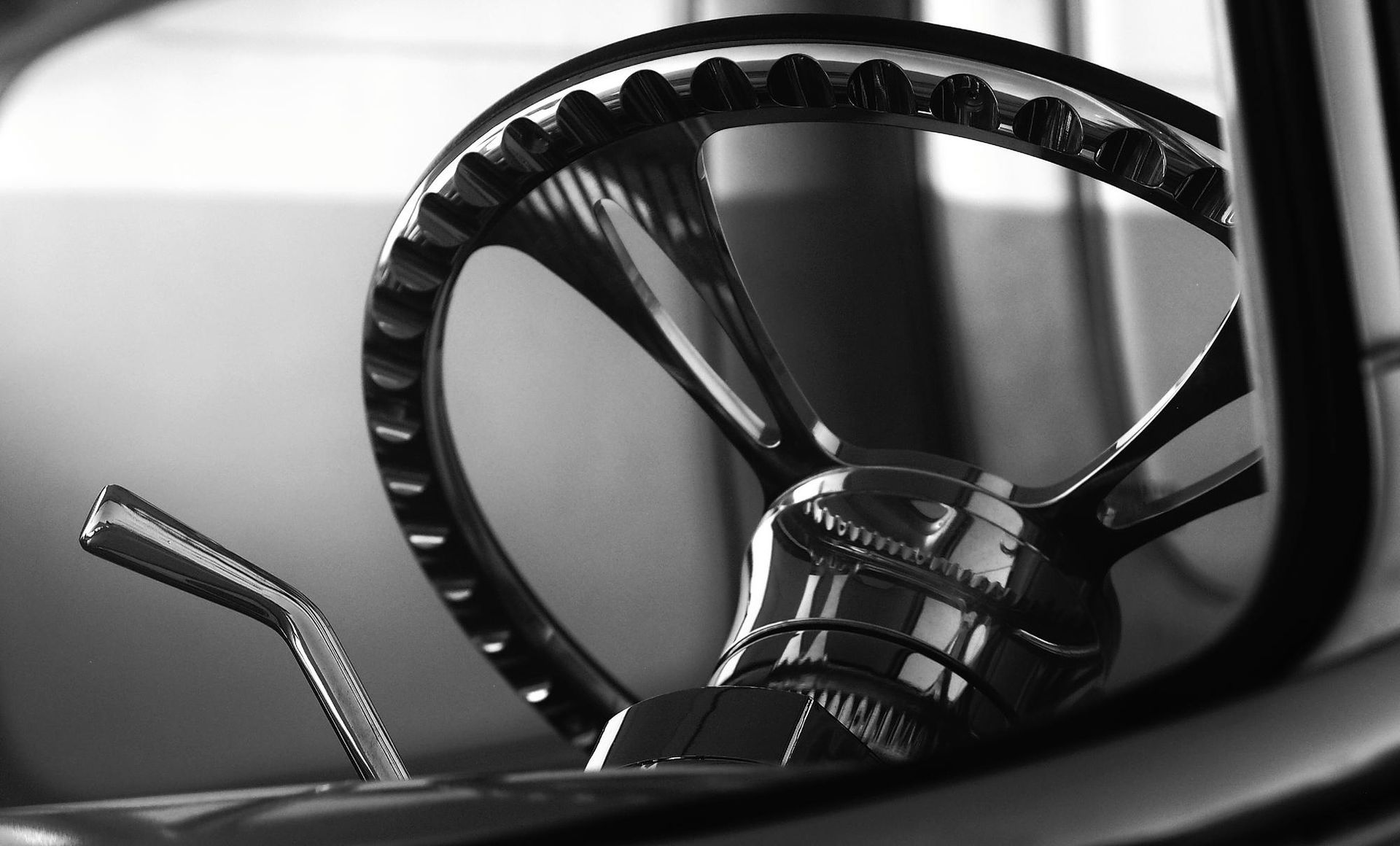 A black and white photo of a steering wheel in a car