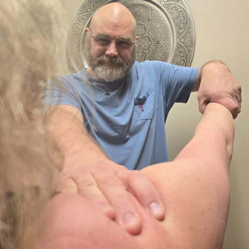 Lance Thompson giving a woman a shoulder massage.