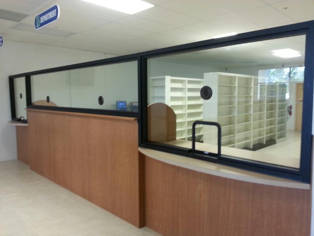 Service counter with glass windows and wooden paneling; an interior room is visible.