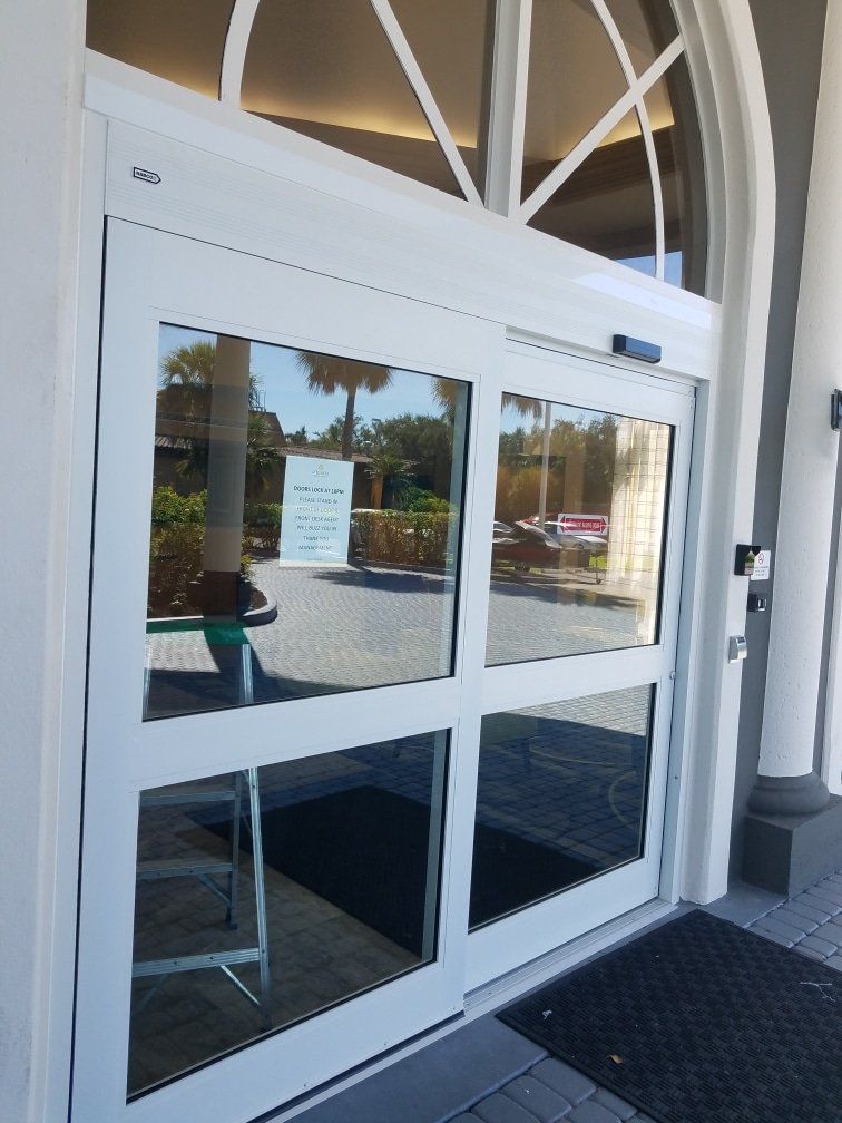 Automatic sliding glass doors with white frames. Exterior shot.