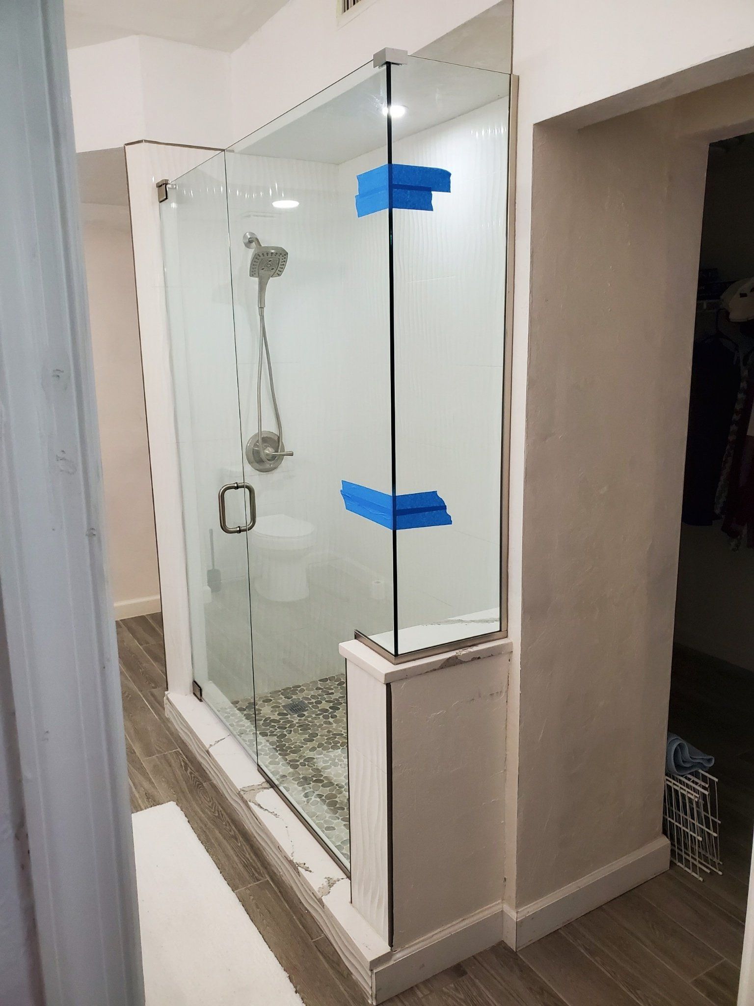 Shower stall with clear glass doors, chrome fixtures, and a white base.