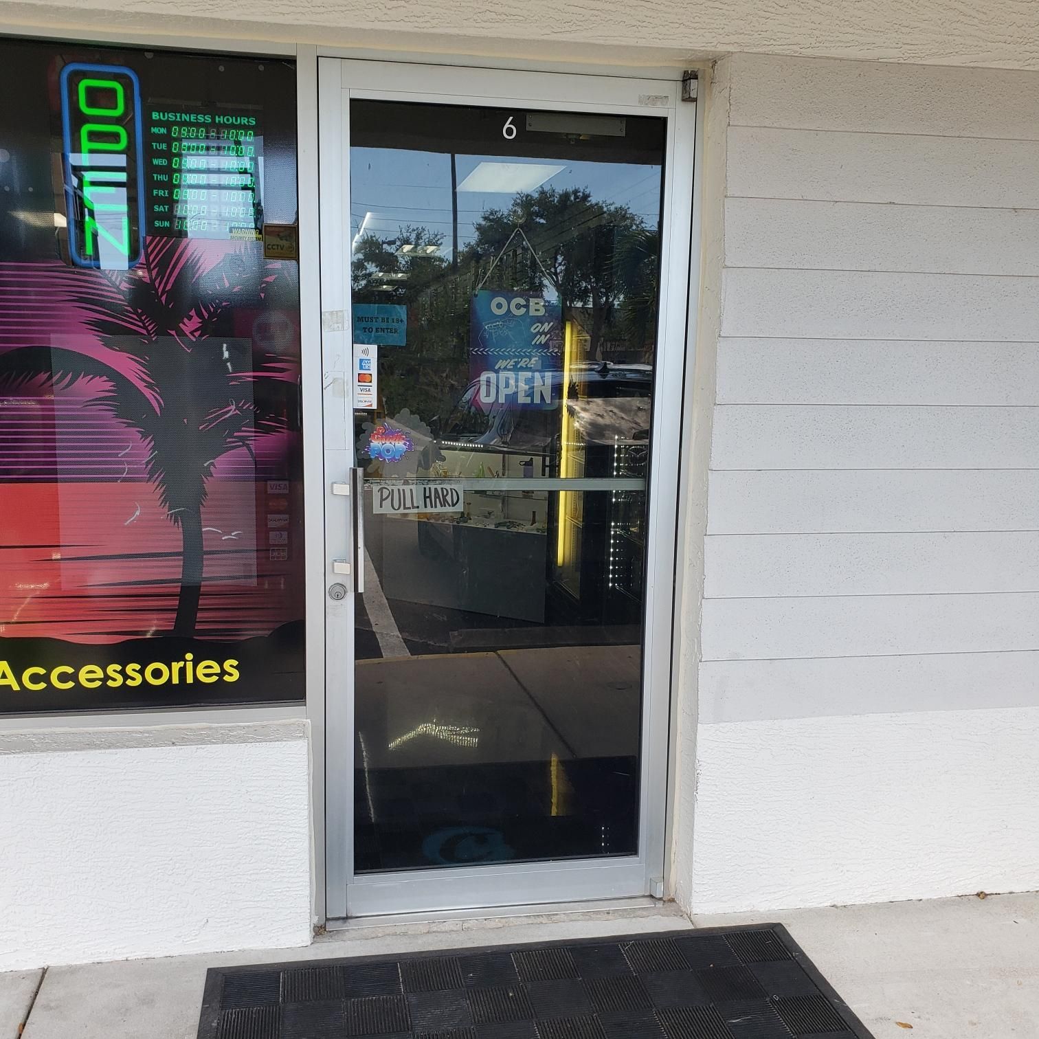 Storefront entrance with a glass door, OPEN sign, and 