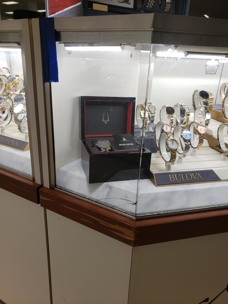 Jewelry store display with Bulova watches, some on stands, and one watch in a box.