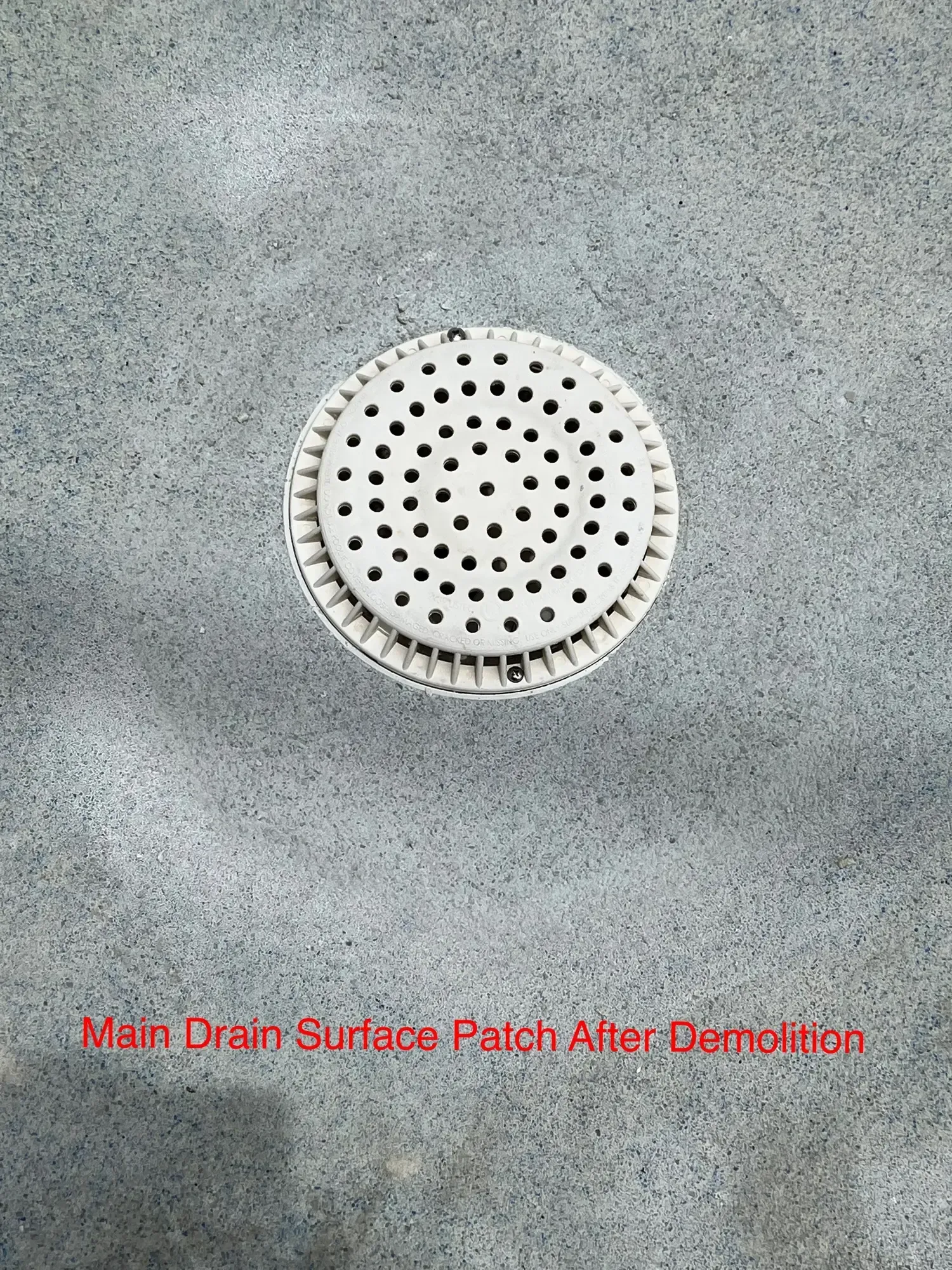 H20 Leak Solution- A white drain cover with black dots on a gray surface.