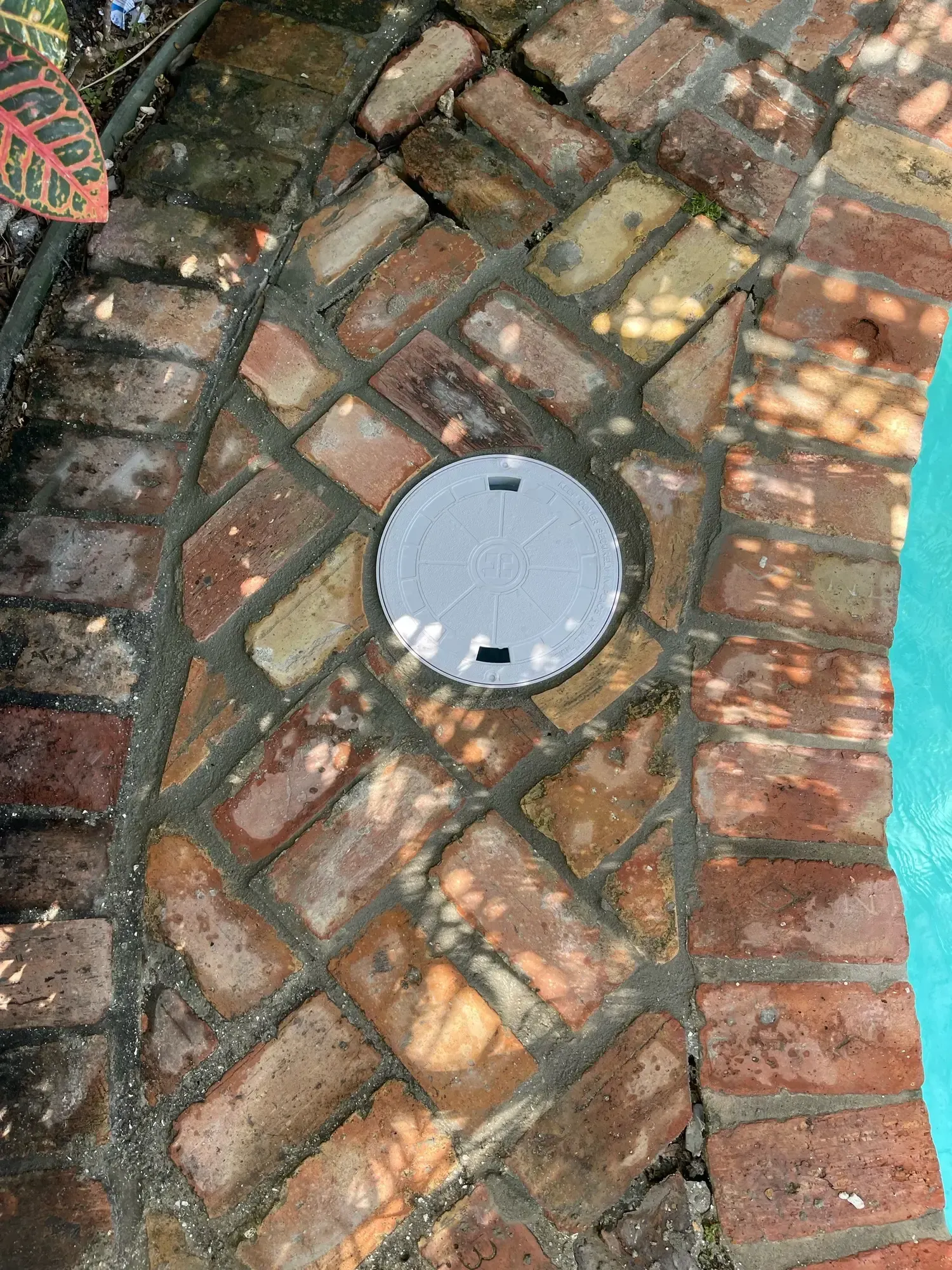H20 Leak Solution- A close up of a brick walkway next to a pool.
