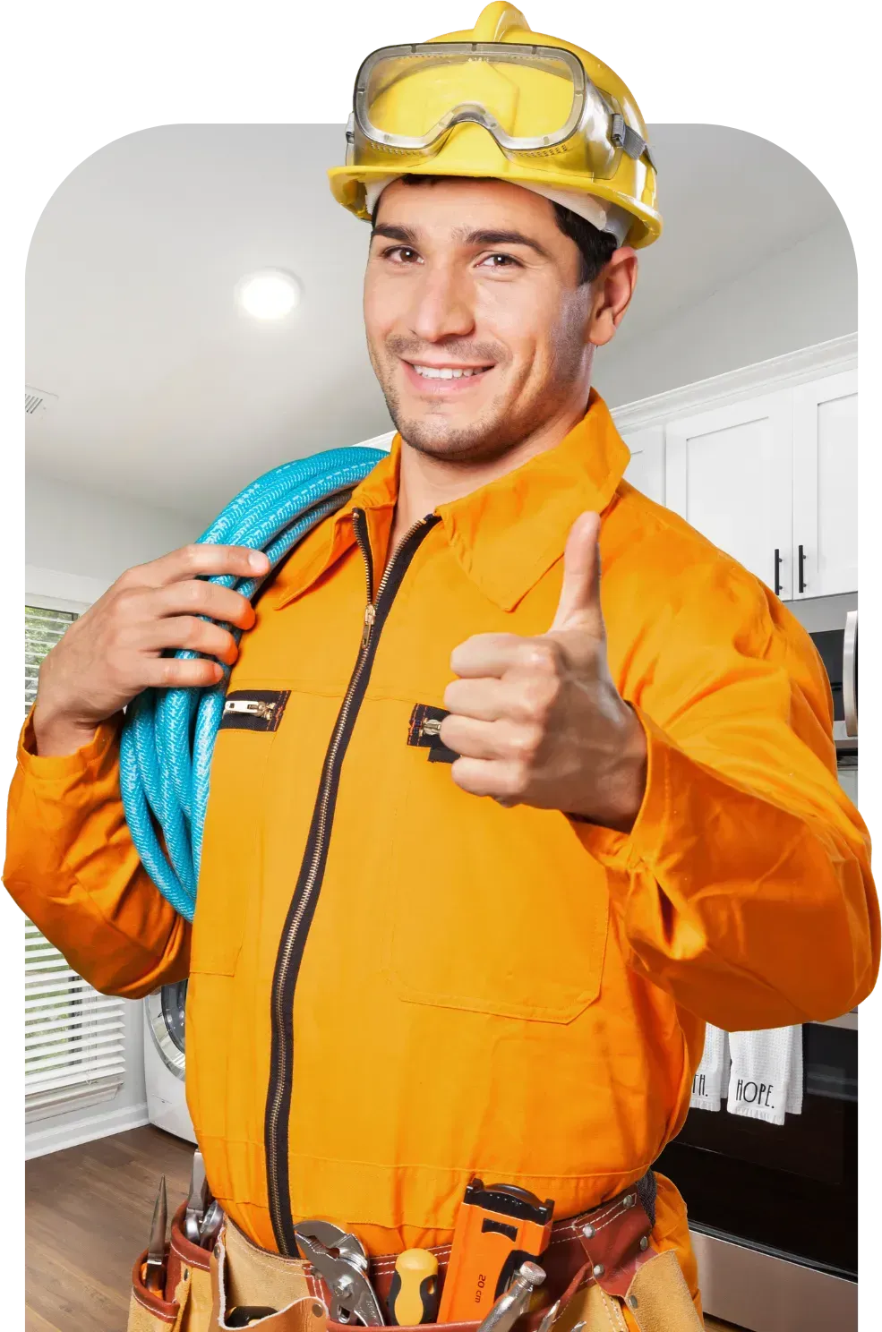 Electrician in orange jumpsuit with thumbs up, holding cable; wearing hard hat and goggles.