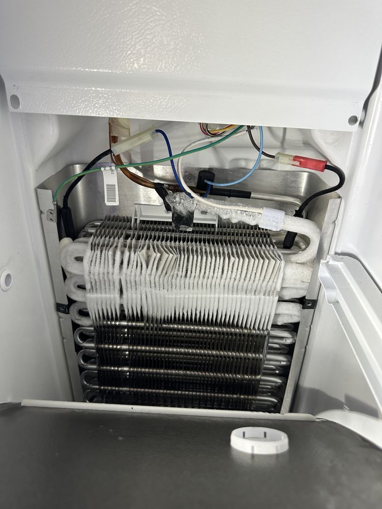 Inside of a refrigerator freezer with a heavily frosted coil.