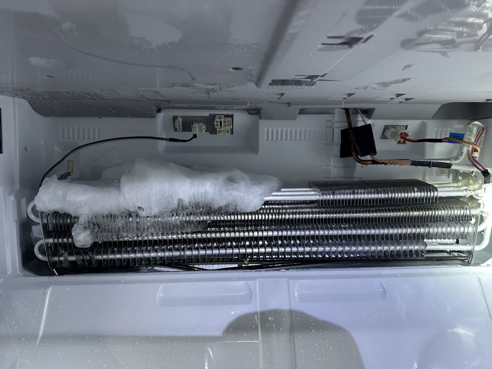 Inside a refrigerator, evaporator coils are heavily frosted.