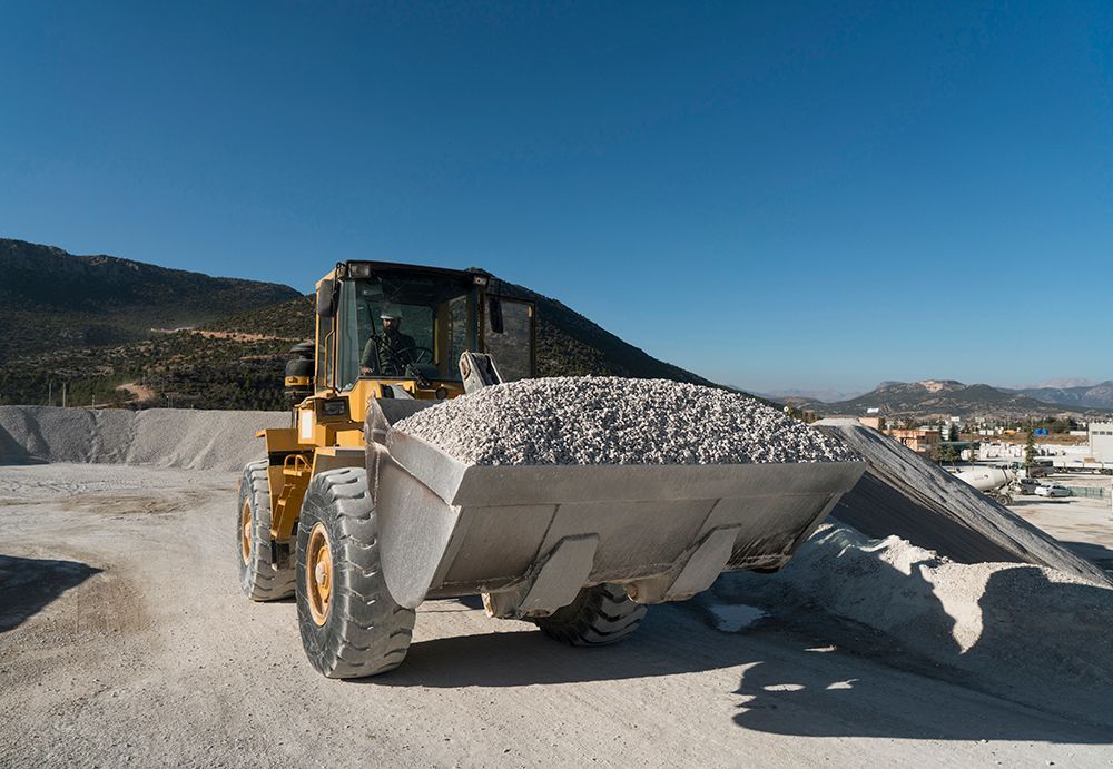 A bulldozer is loading gravel into a bucket.
