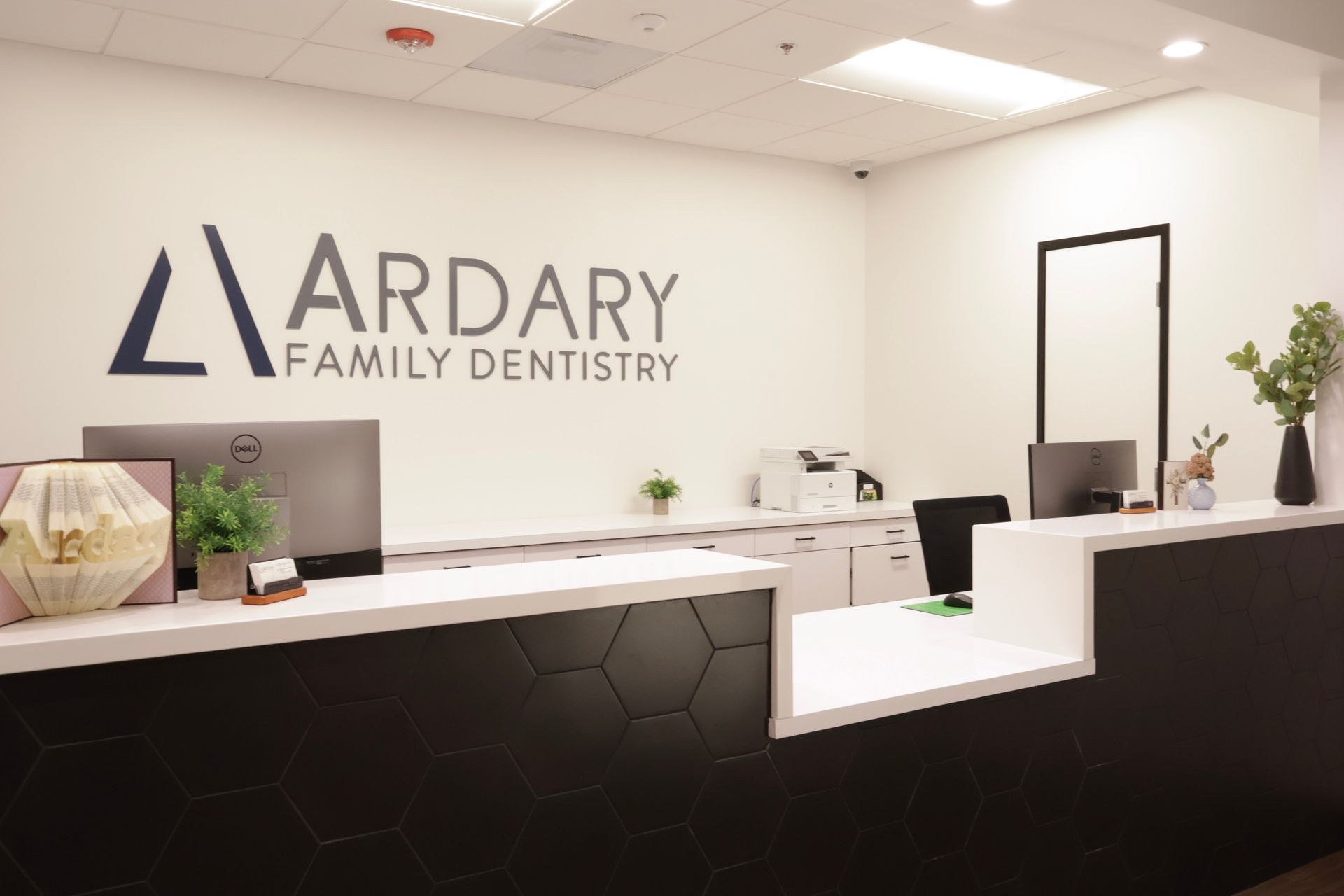 Reception area of Ardary Family Dentistry with logo, desk, and computer.