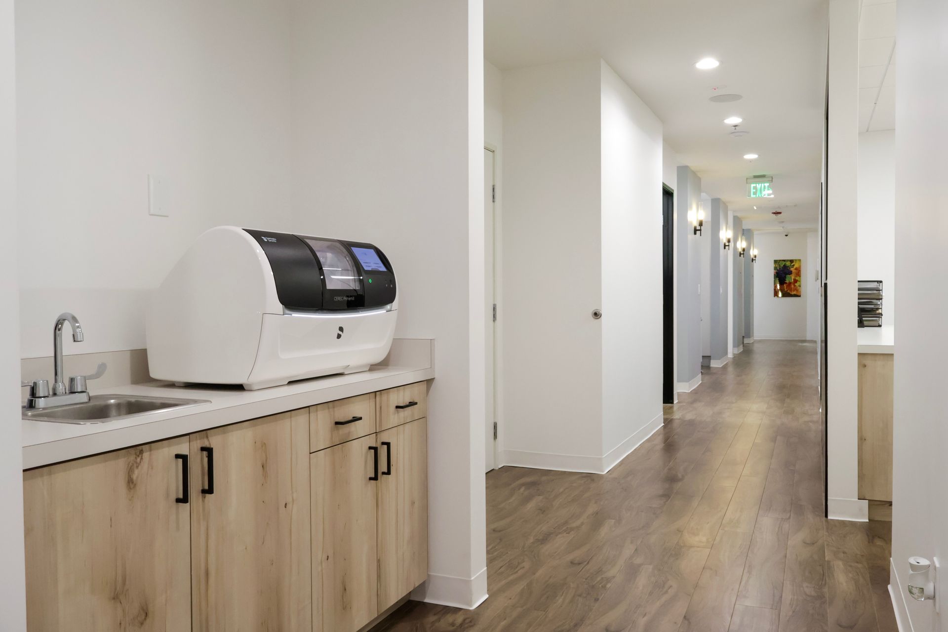 Hallway with a dental office machine, a sink, and cabinets.