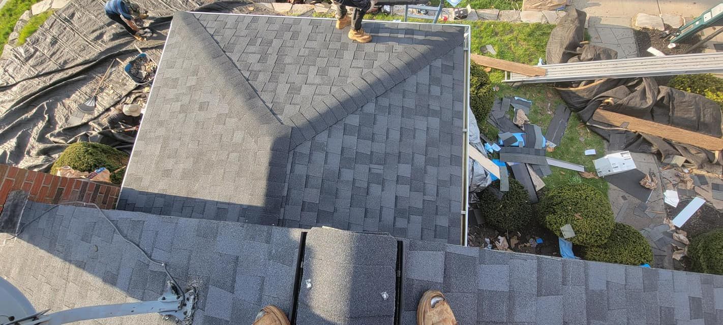 A person is standing on the roof of a house.