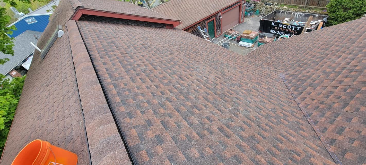 An aerial view of a roof of a house with a pool in the background.