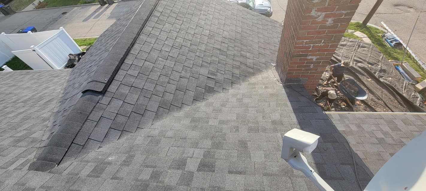 A roof with a chimney and a satellite dish on it.