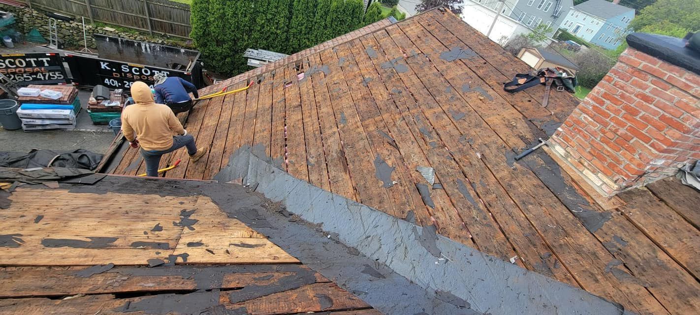 Two men are working on the roof of a house.