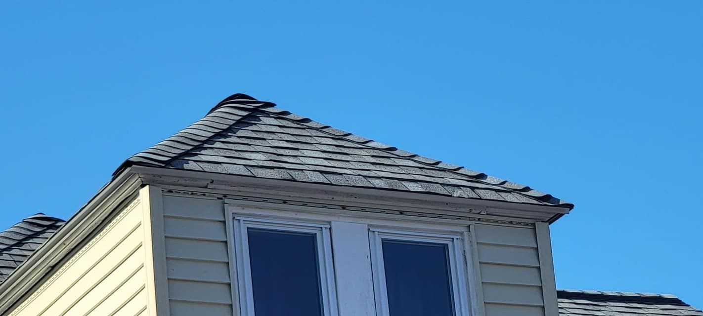 The roof of a house with a blue sky in the background.
