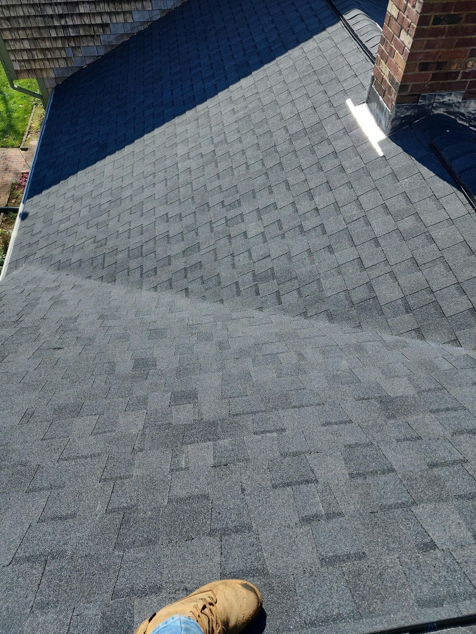 A person is standing on the roof of a house.